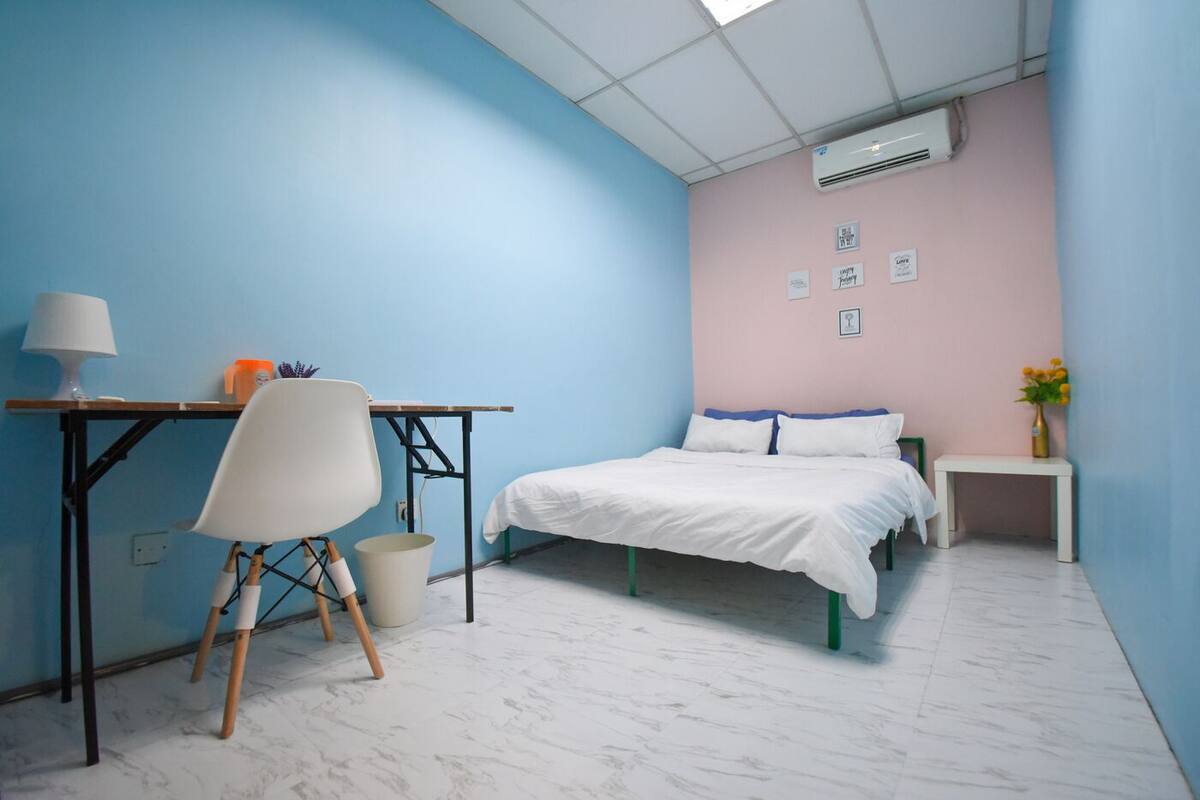 Une chambre à coucher avec un lit, un bureau, une chaise et une table de chevet.