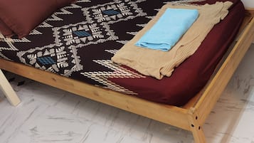 1 habitación, cubrecamas, escritorio y tabla de planchar con plancha