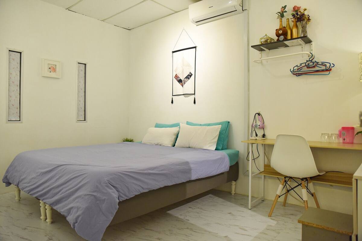 Une chambre bien rangée, avec un lit, un bureau et une chaise.