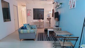 Una sala moderna con un sofá, una mesa de comedor y un televisor.