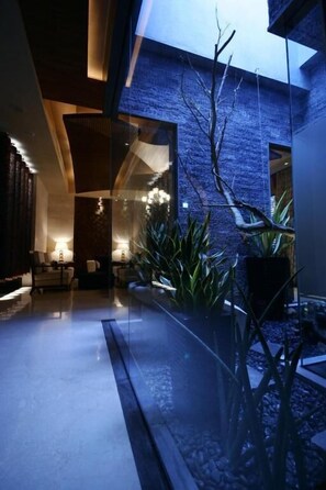 A modern interior with a glass partition, seating area, and a stone wall. - THE YORKER De'luxe Motel (Taoyuan City)