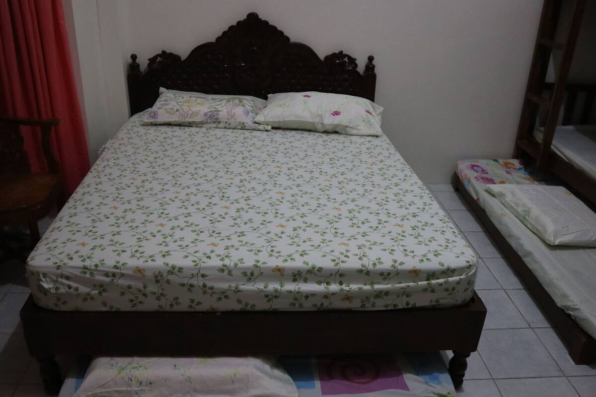 A bedroom with a bed, a chair, and a small table.