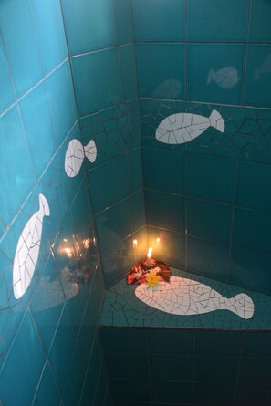 Casa de banho com azulejos azuis e motivos de peixes.