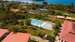 Vista aérea de un resort con piscina, playa y vistas al océano.