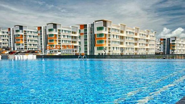 A swimming pool with a modern apartment building in the background. - Quin Homestay (Kota Kinabalu)