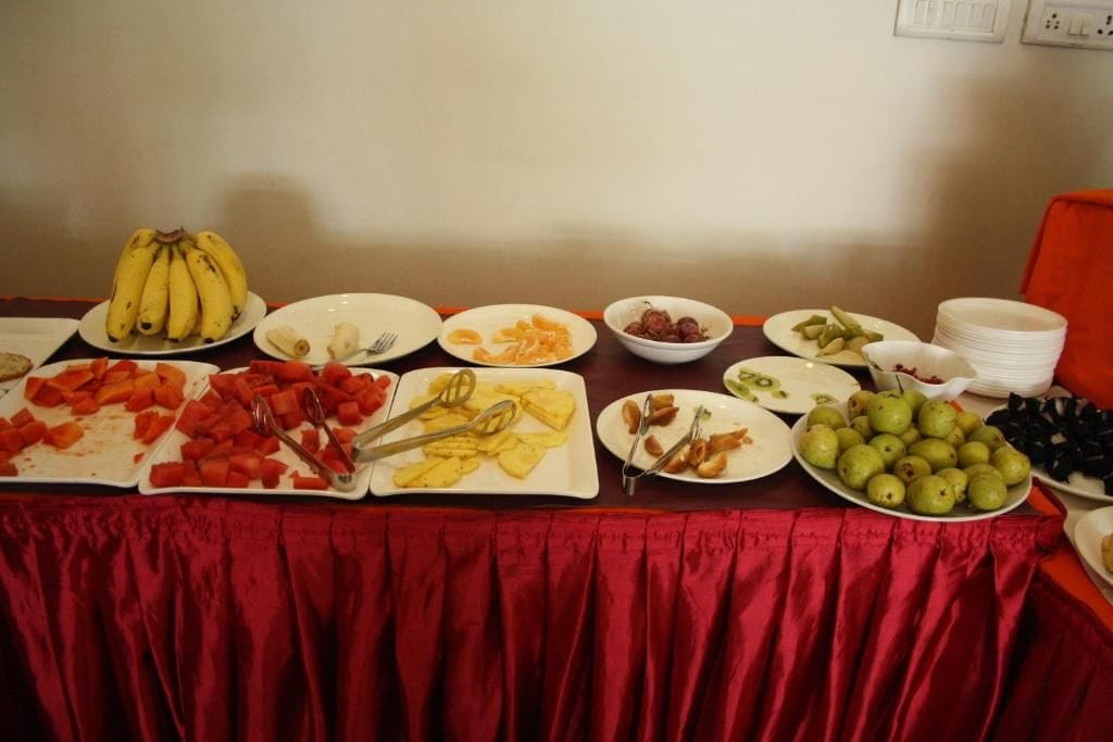 Ein Buffet mit verschiedenen Speisen, darunter Bananen, Wassermelone und grünes Obst.