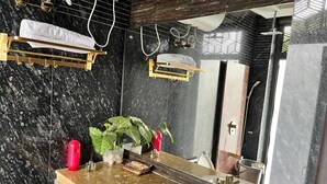 Une salle de bain moderne avec un lavabo en marbre, un grand miroir et un espace douche.