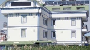 A multi-story building with a flat roof, solar panels, and satellite dishes. - Gozde Hotel (Serik)
