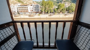 Un balcone con vista sul fiume, sugli edifici e sugli alberi.