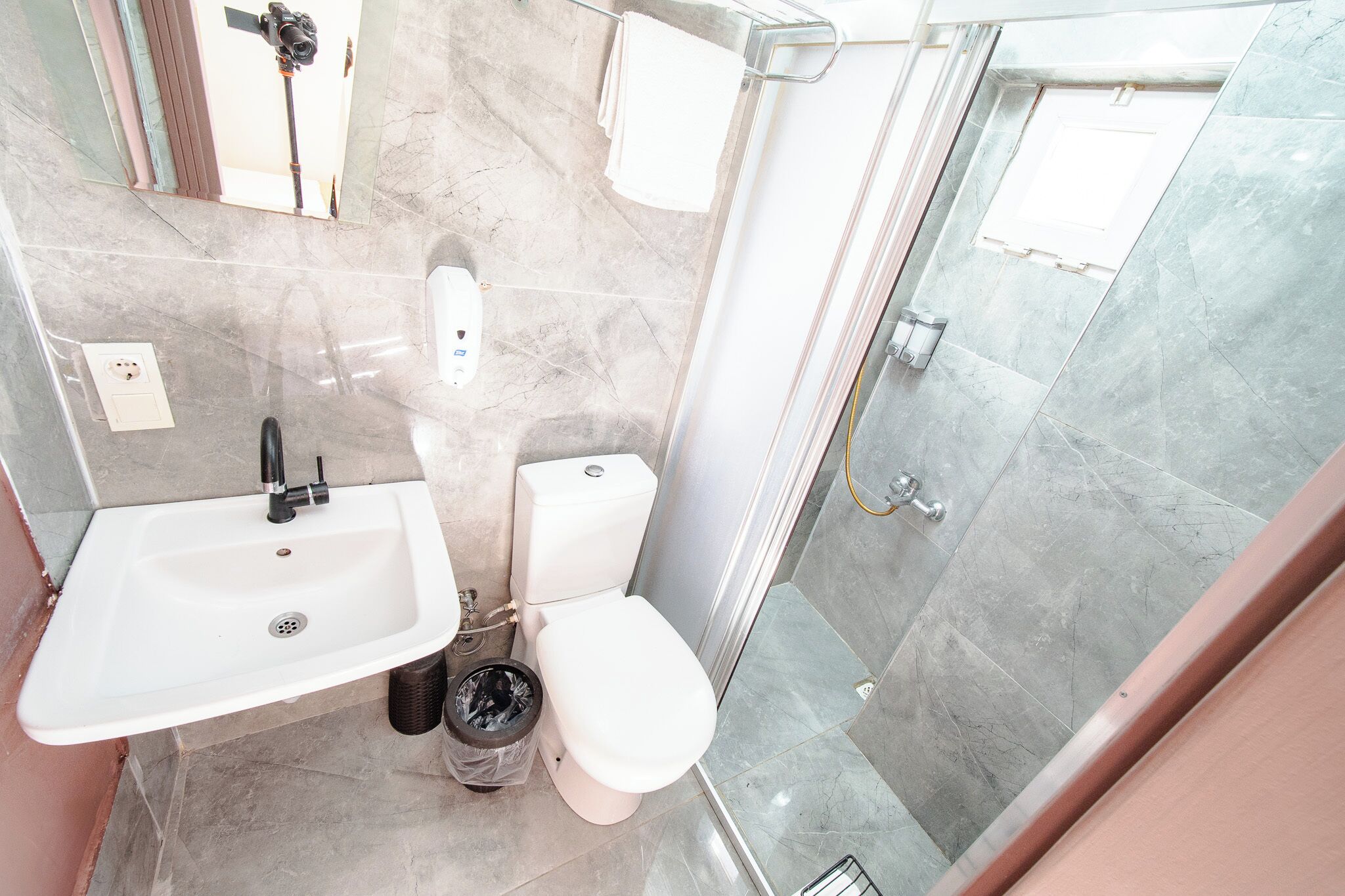 Un baño con lavamanos, inodoro y ducha.
