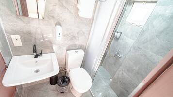 Un baño con lavamanos, inodoro y ducha.