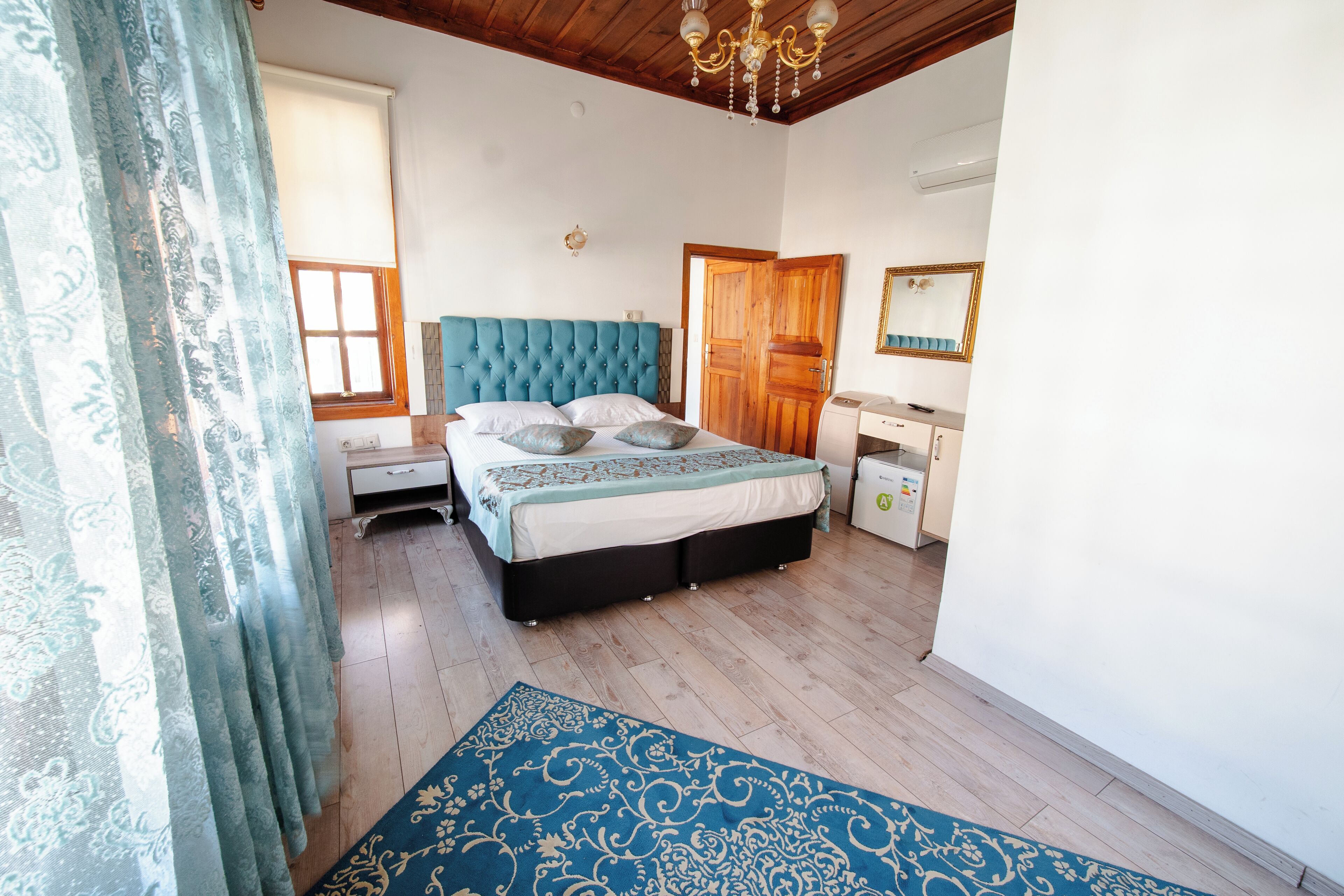 Un dormitorio con una cama, mesitas de noche, cómoda, espejo y candelabro.