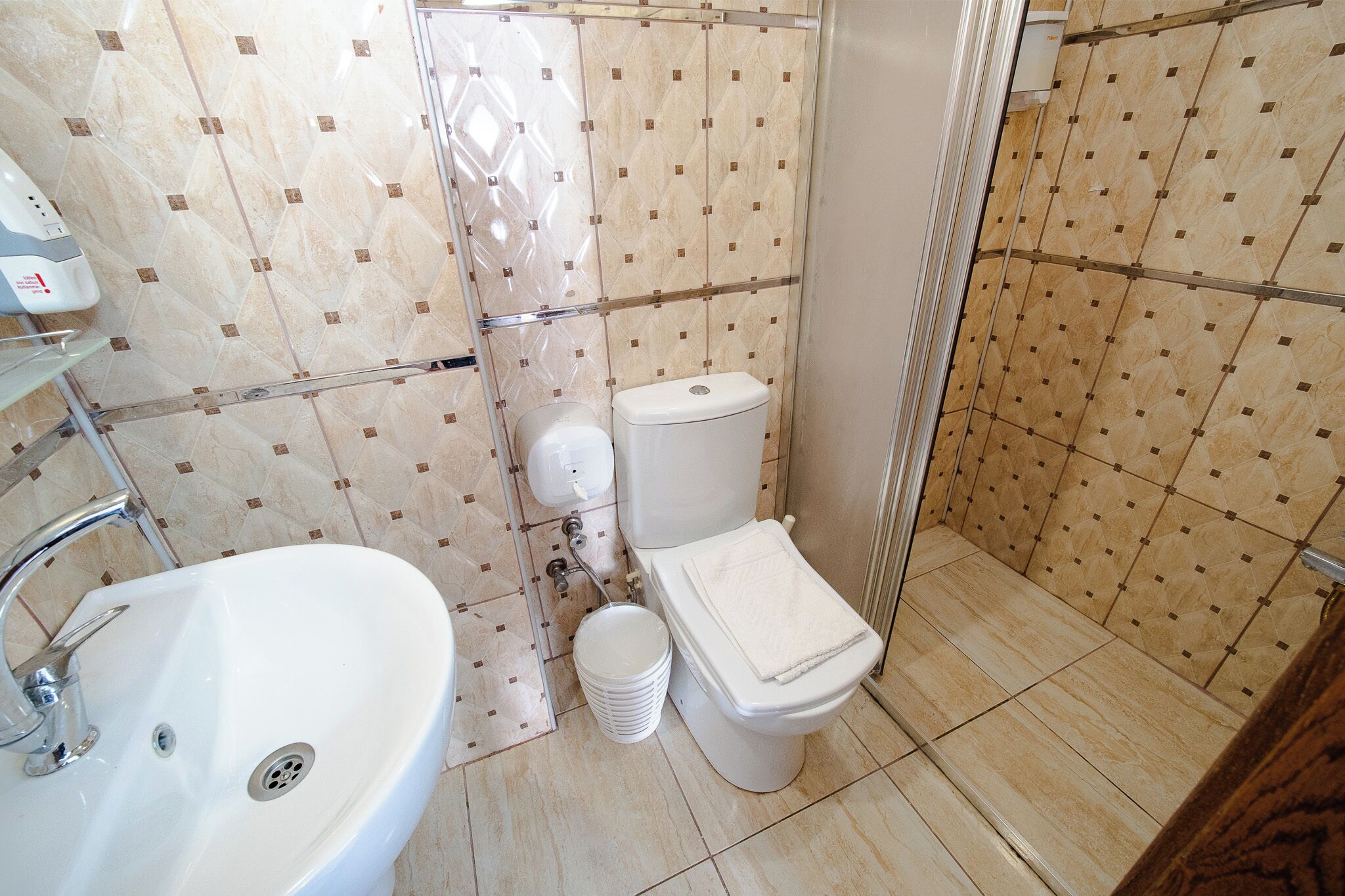 Un baño con lavamanos, inodoro y cabina de ducha.