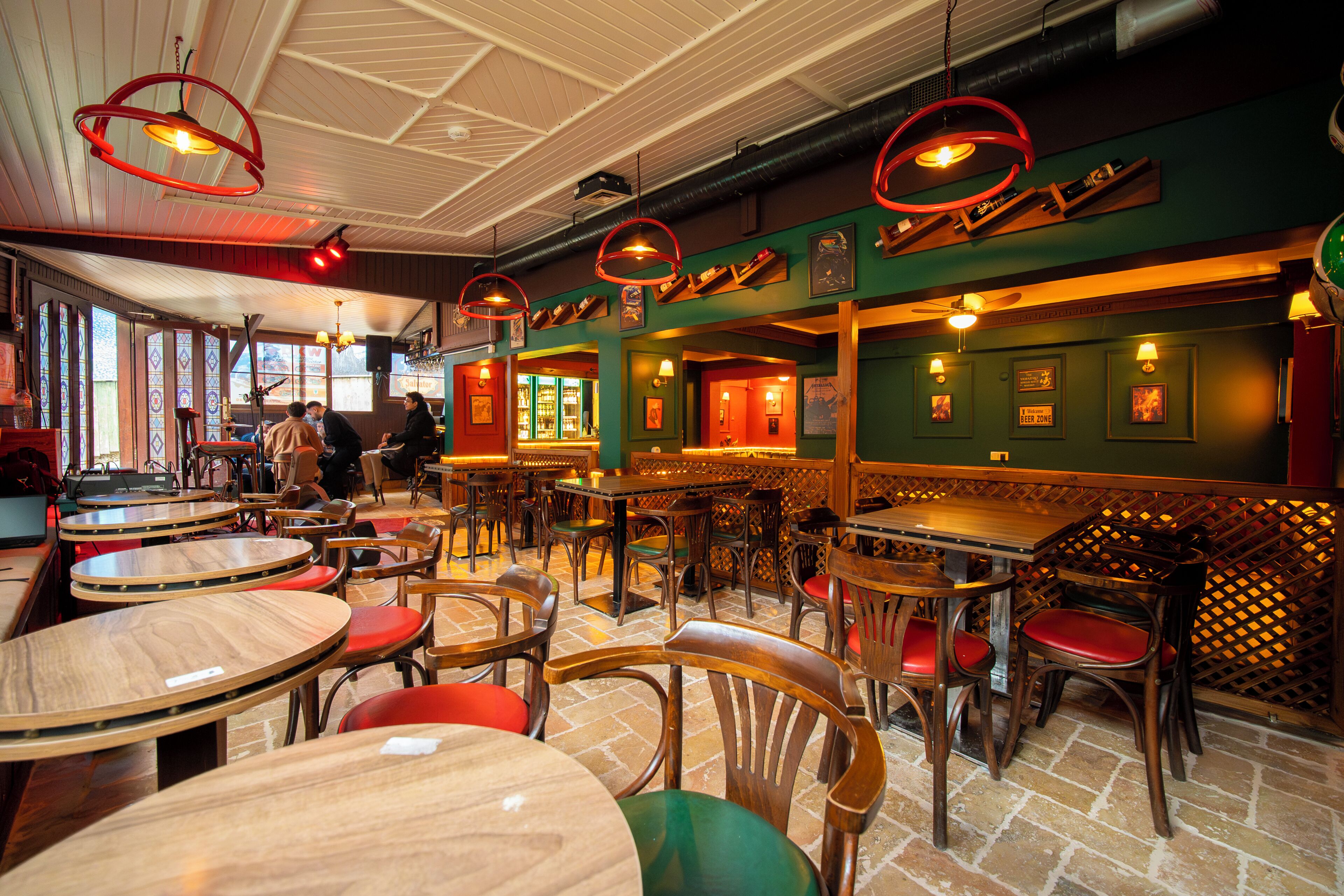 Interior de restaurant amb diverses taules i cadires rodones, una zona de bar i vistes a través de les finestres.