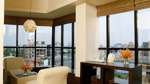 A modern hotel room with large windows, a desk, and a seating area. - Imperial Regency (Kanayannur)