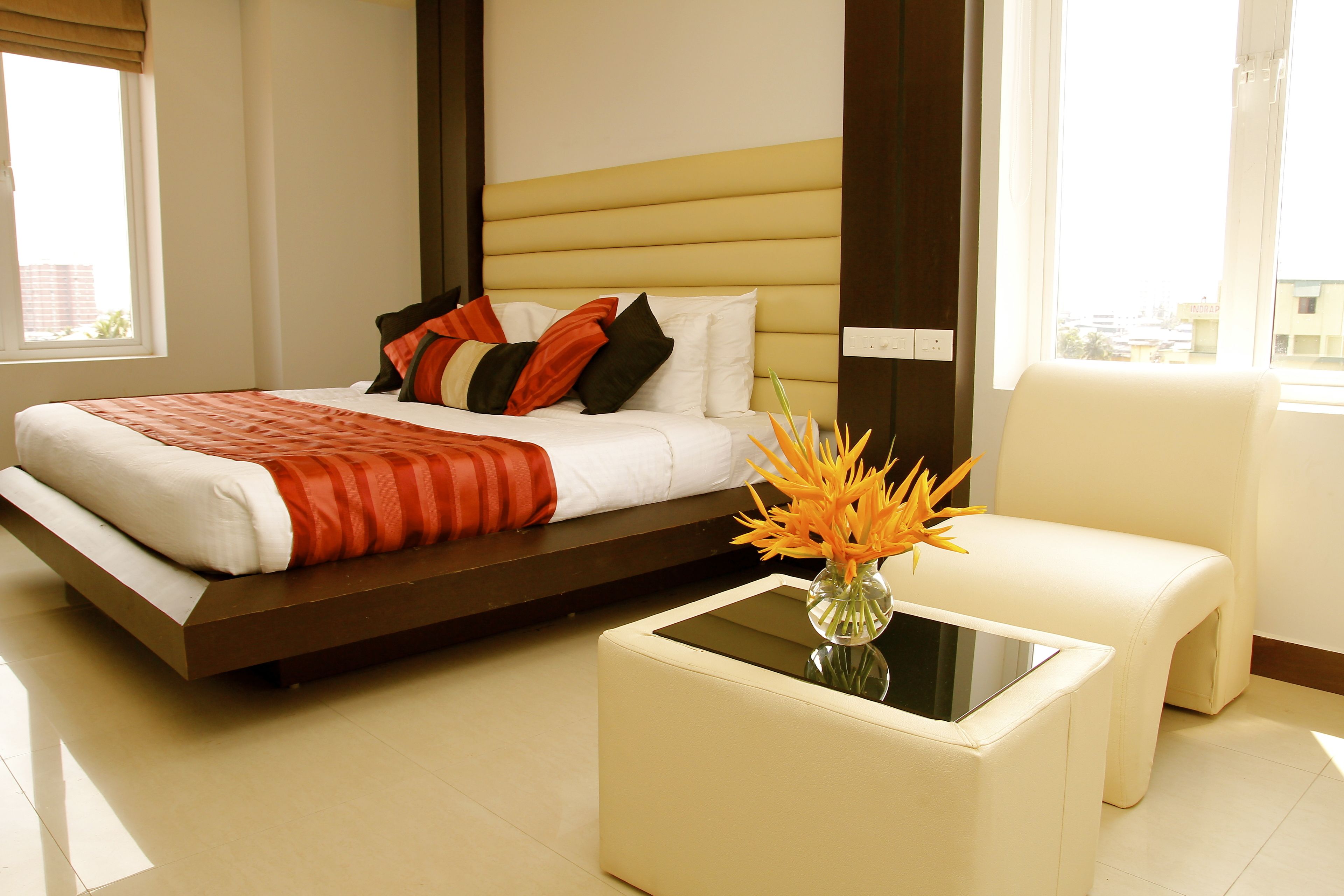 A modern hotel room with a bed, a small table, and a chair.
