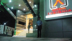 A building entrance with a sign for 'Imperial Insignia' and a security guard standing in front. - Imperial Regency (Kanayannur)