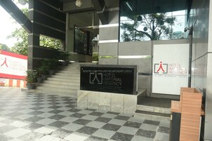 A hotel entrance with a checkered floor, a staircase, and a sign for the Hotel Imperial Regency.