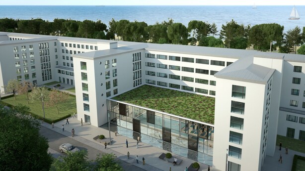 Un bâtiment moderne doté d’un toit plat, de grandes fenêtres et d’une cour intérieure avec une pelouse.