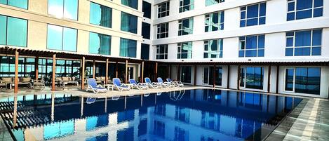 Una piscina al aire libre, tumbonas