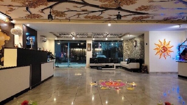 En hotellobby med en receptionsdisk, en sittgrupp och ett dekorativt tak.