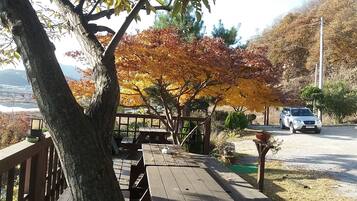A wooden deck with a view of a lake and autumn trees.