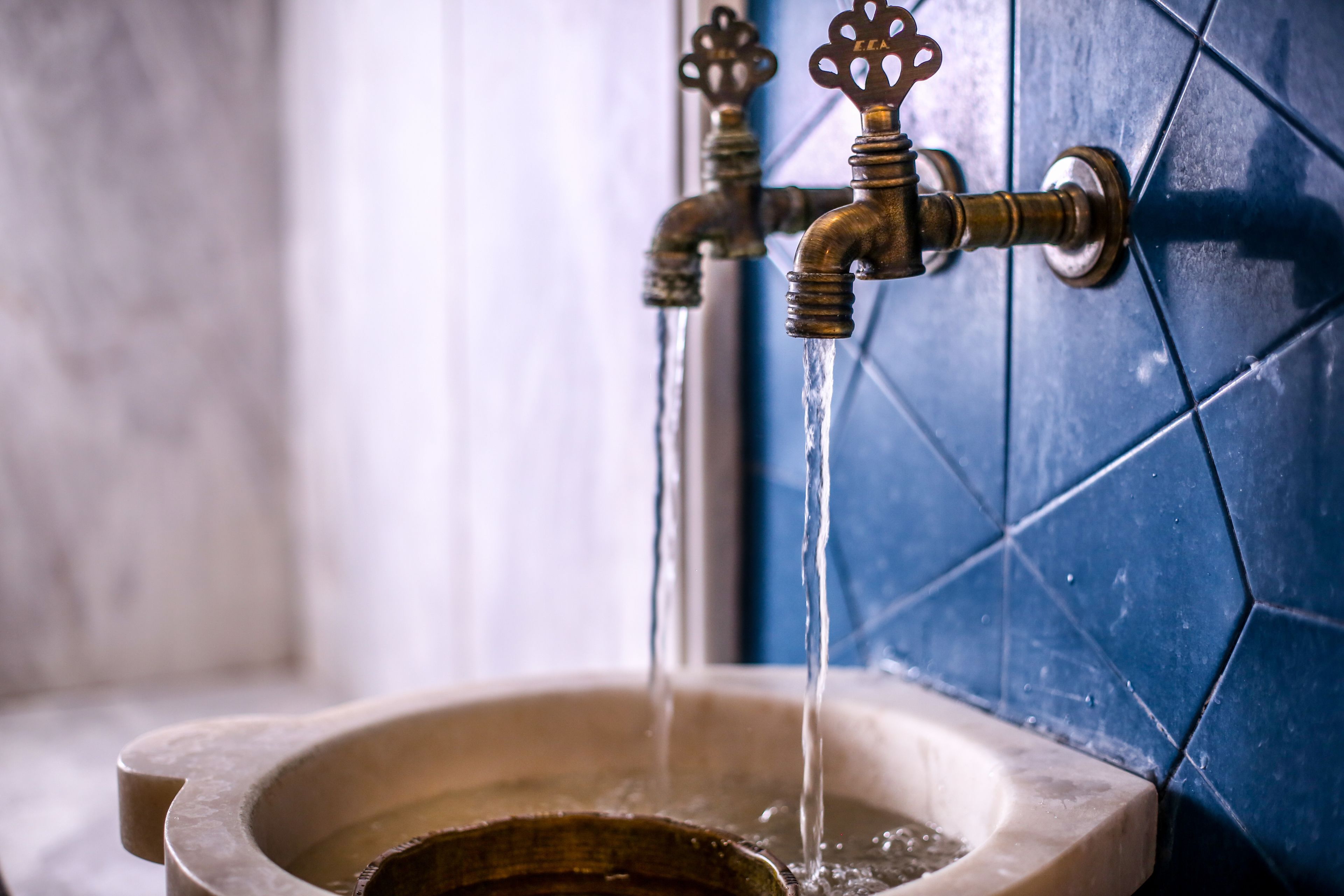 Un baño con un lavamanos de estilo vintage y dos grifos decorativos.