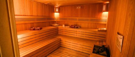 Una sauna con bancos de madera, algunos con toallas y otros con toallas y una bolsa.