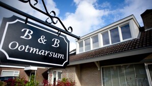 Placa para 'B & B Ootmarsum', com vista clara da fachada de tijolos e janelas do edifício.