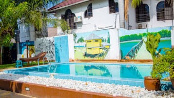 Una piscina al aire libre, sillones reclinables de piscina