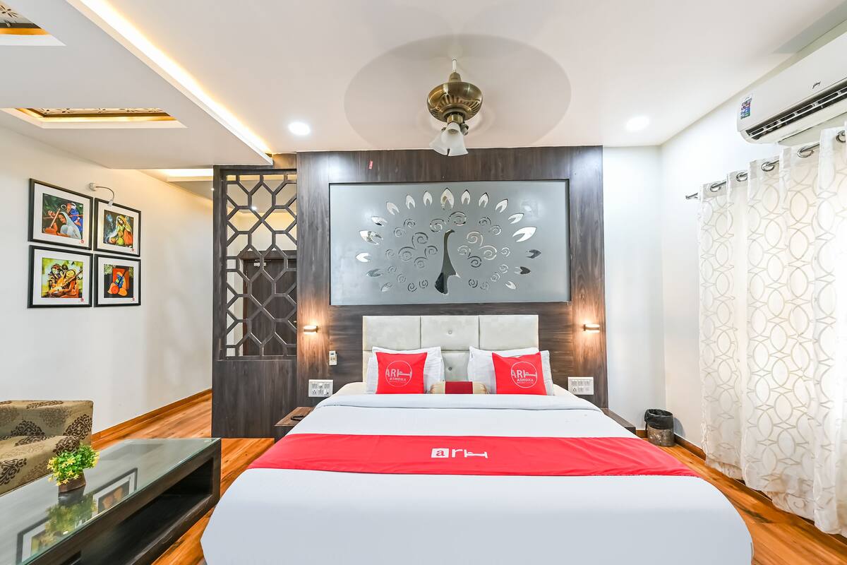 A modern hotel room with a large bed, a decorative wall piece, and a ceiling fan.