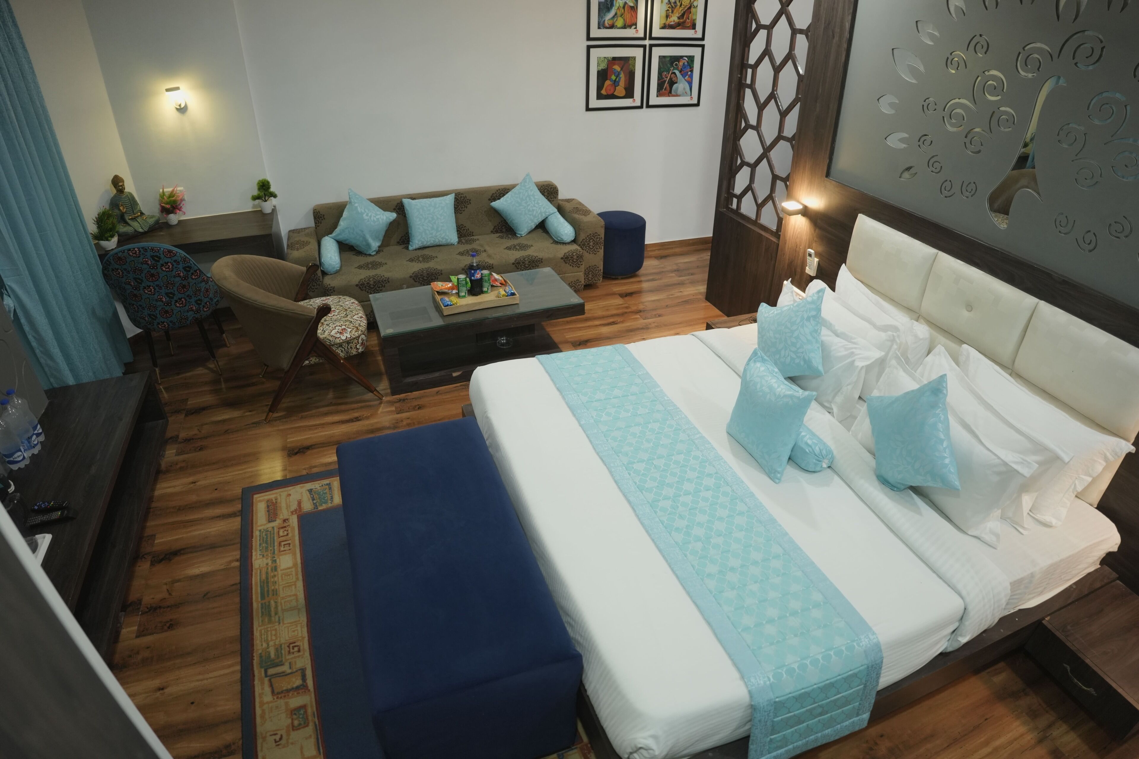 Une chambre d’hôtel avec un lit, un canapé, une table basse et une chaise.