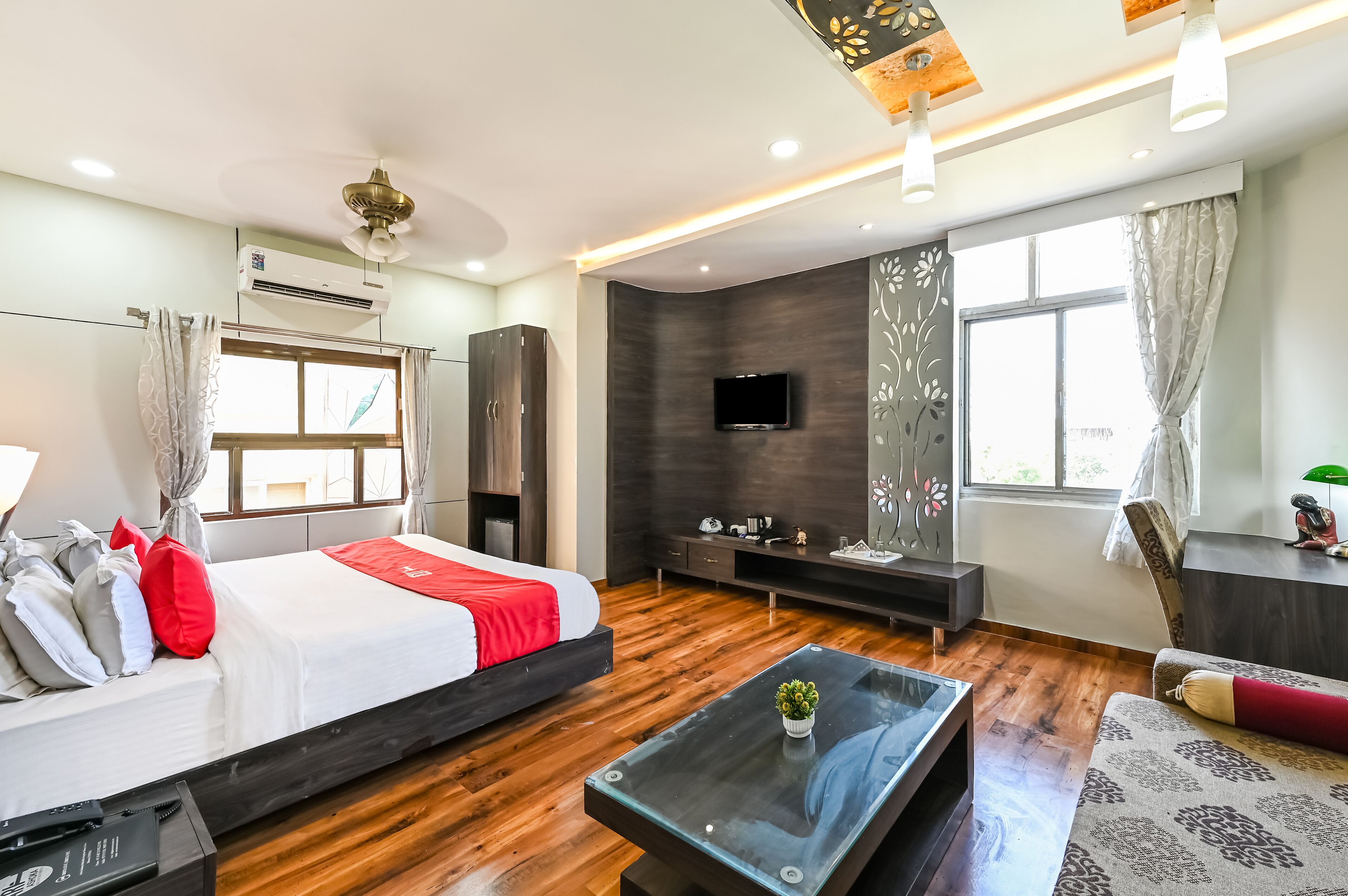 Una habitación de hotel moderna con cama, televisor, escritorio y ventana.