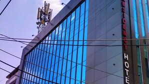 A modern hotel building with a prominent glass facade and signage for 'Ashoka Residency Hotel'. - Ashoka Residency Hotel (Bhilwara)