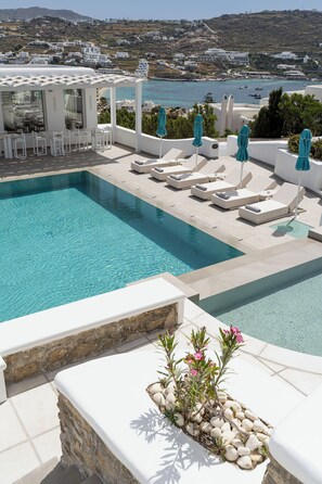 A pool with lounge chairs and a view of the sea. - Kallos of Mykonos (Mykonos)