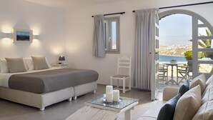 A modern bedroom with a bed, bedside table, and a view of the sea. - Kallos of Mykonos (Mykonos)
