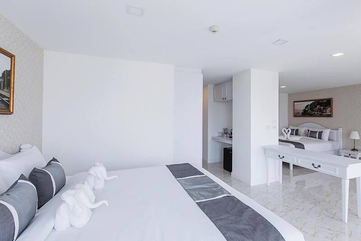 Una habitación de hotel con una cama grande, un escritorio y vistas a la ciudad a través de la ventana.