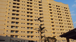 A high-rise building with multiple floors, each featuring numerous windows and balconies. - Apartamento Grand Dolphin - Férias em Caldas Novas (Caldas Novas)