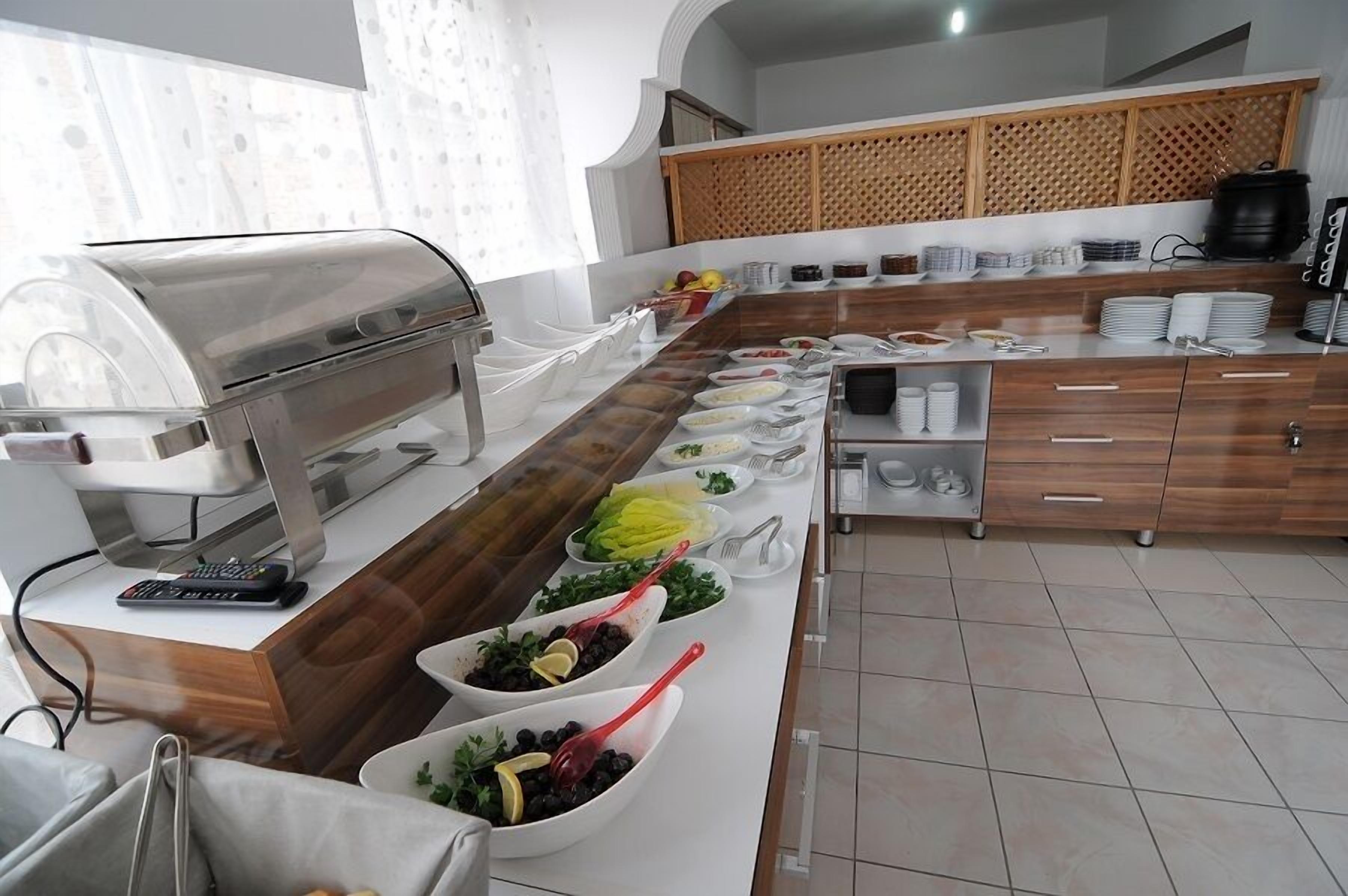 A buffet setup with a grill, various food items, and a wooden counter.