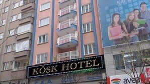 A multi-story hotel with balconies, a visible sign for 'KOSK HOTEL', and various storefronts including 'AVEA'. - Kosk Hotel (Elazig)