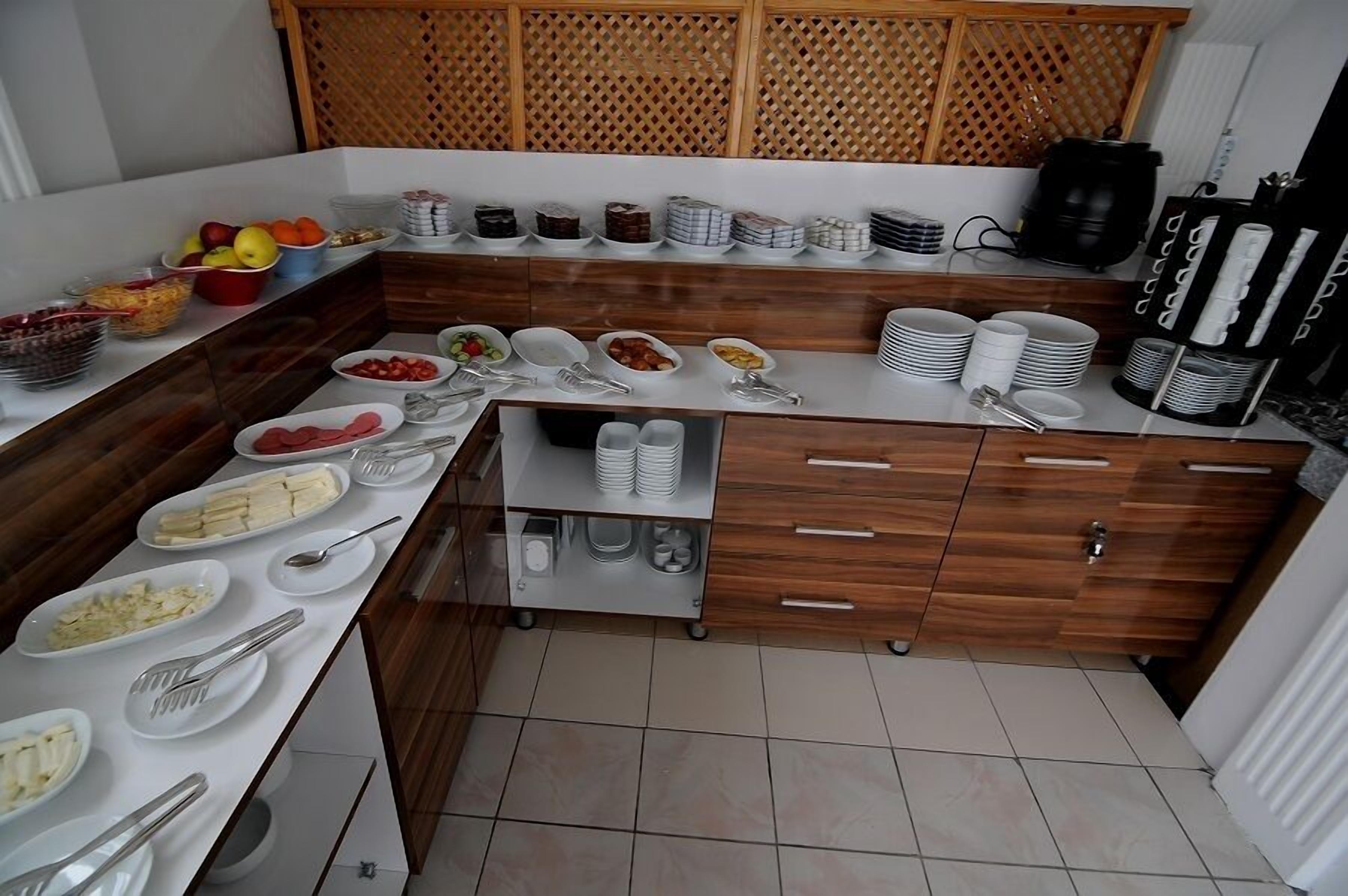 Montaje de bufé con diversos alimentos y utensilios de servicio.