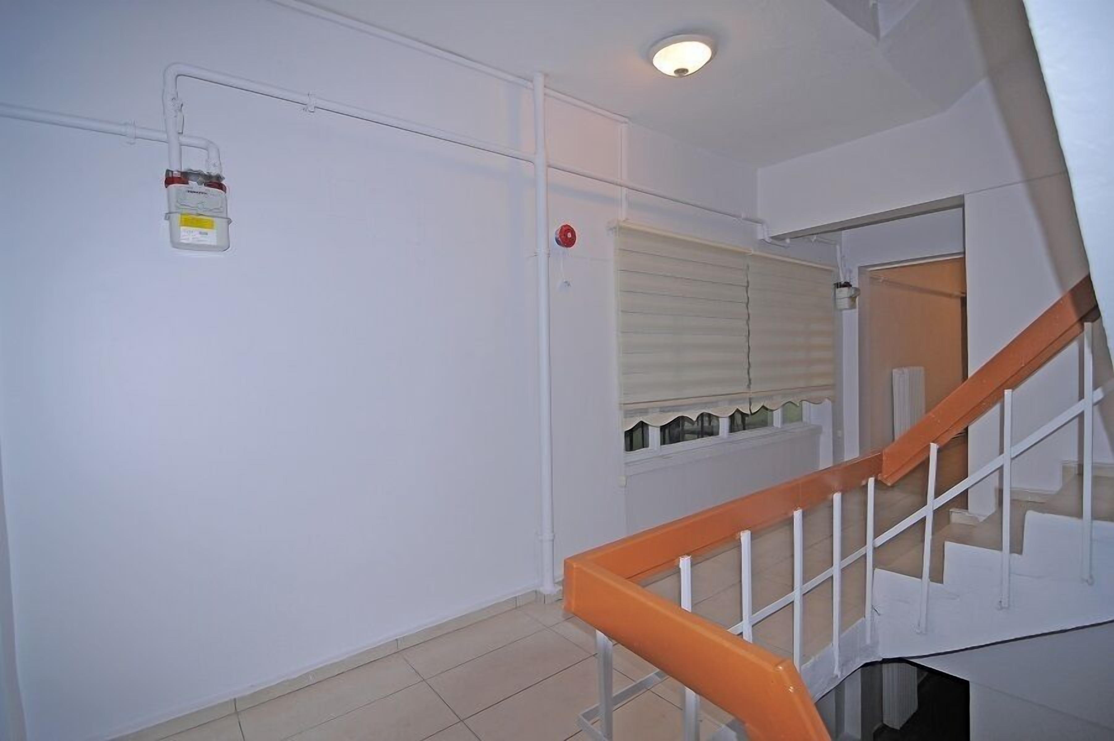 A staircase with a wooden handrail and white walls.