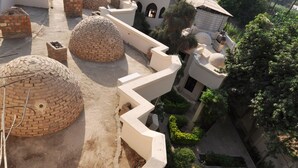 A rooftop with multiple spherical structures, a pathway, and surrounding greenery. - El Nakhil Hotel (Luxor)