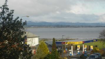 A fuel station with a view of a lake and mountains in the background.
