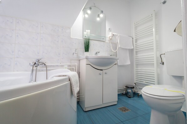 A modern bathroom with a bathtub, sink, and toilet. - Vila Marioara (Sibiu)