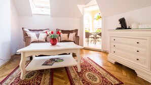 A cozy living room with a sofa, coffee table, and a white cabinet. - Vila Marioara (Sibiu)