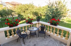 A balcony with a round table and two chairs, surrounded by a balustrade. - Vila Marioara (Sibiu)