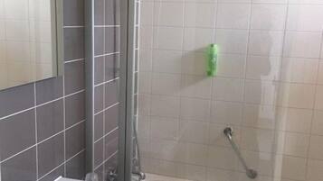 A bathroom with a shower, a sink, and a mirror.