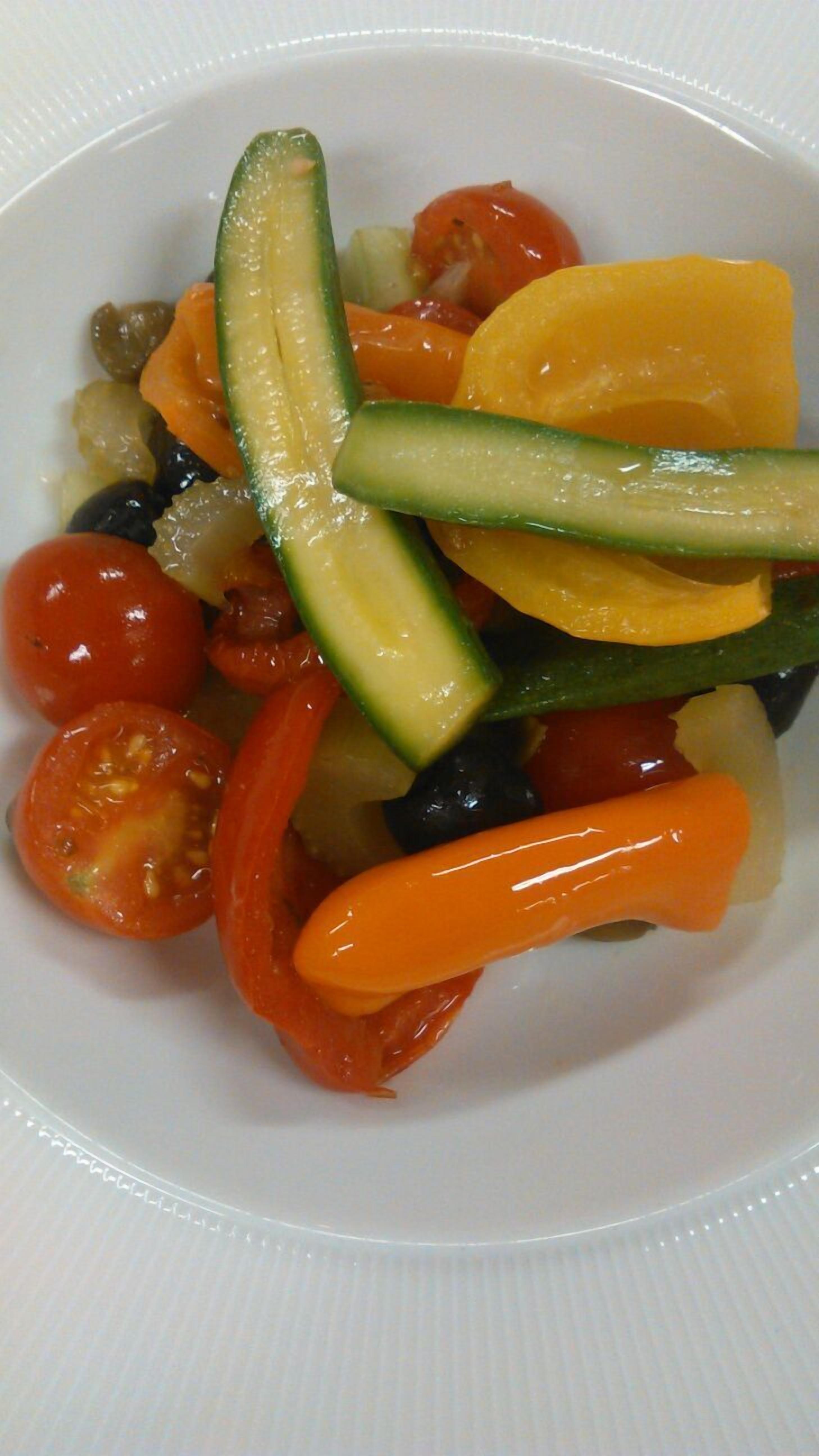 Un plato blanco con una variedad de verduras en rodajas.