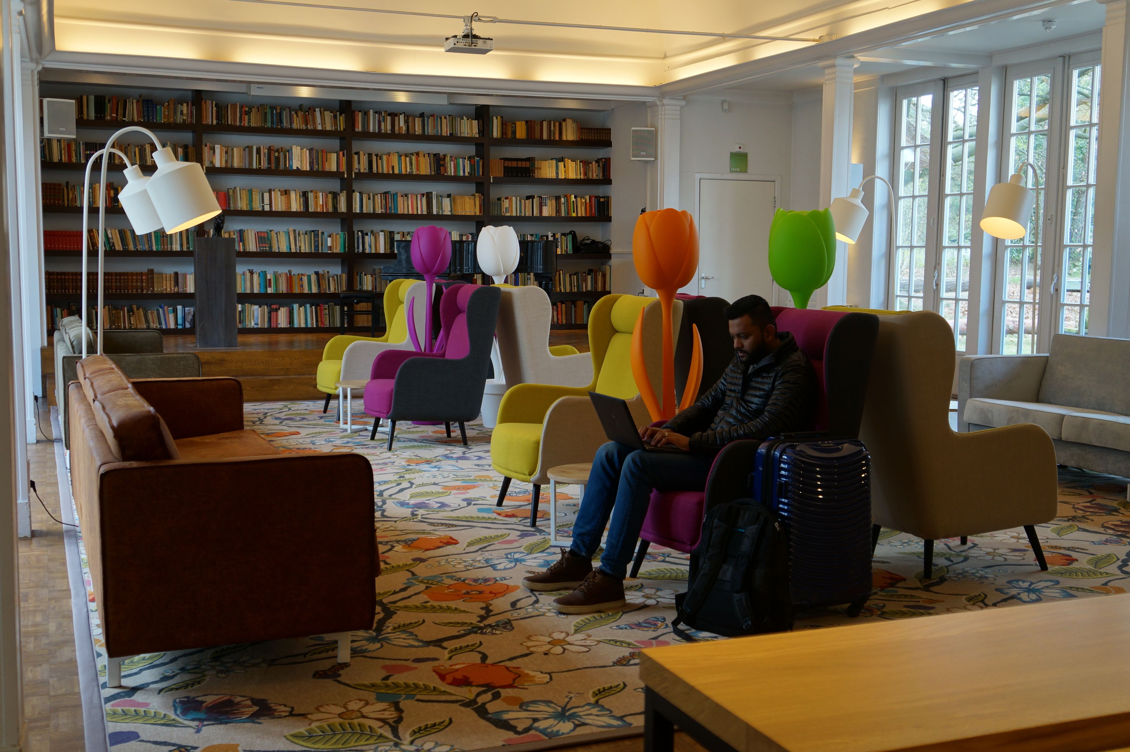 A library with colorful chairs and a large bookshelf.